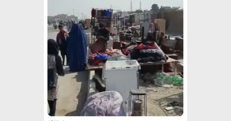 काबुल की एक सड़क पर अपने घर का सामान बेचता एक अफगानी