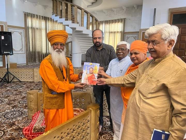 बैठक के दौरान महामंडलेश्वर श्री 108 बबलदास जी महाराज को एक पुस्तक भेंट करते दाएं से श्री आलोक कुमार, आचार्य भारतभूषण दास जी, श्री देवजीभाई रावत और एक अन्य कार्यकर्ता