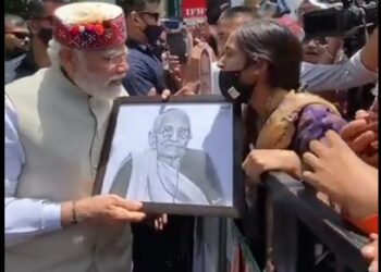 प्रधानमंत्री श्री नरेंद्र मोदी को पेंटिंग भेंट करती हुई युवती