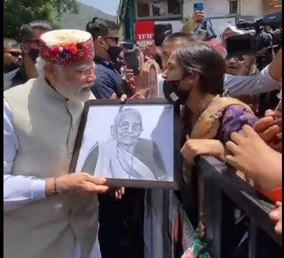 प्रधानमंत्री श्री नरेंद्र मोदी को पेंटिंग भेंट करती हुई युवती