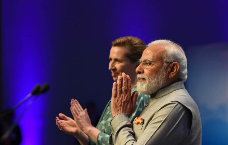 डेनमार्क में भारतीय समुदाय का अभिवादन करते प्रधानमंत्री नरेंद्र मोदी। साथ में डेनमार्क की प्रधानमंत्री मेटे फ्रेडरिक्सन।
