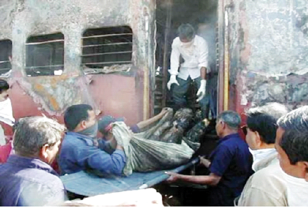 गोधरा में 27 जनवरी, 2002 को जलाई गई साबरमती एक्सप्रेस  से कारसेवकों के शव को निकलते कर्मी (फाइल फोटो)