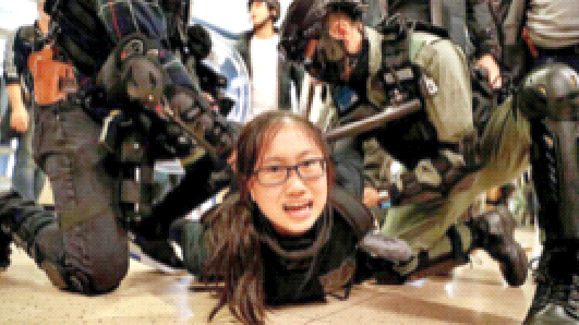 एक लोकतंत्र समर्थक कार्यकर्ता को दबोचते हुए हांगकांग के पुलिस ‘कर्र्मी (फाइल चित्र)