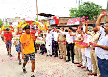 उत्तर प्रदेश में कांवड़ियों पर फूल बरसाते डीएम, एसपी और अन्य गणमान्य व्यक्ति