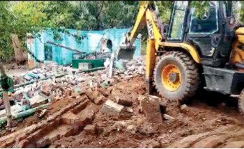 एक अवैध मजार को ध्वस्त करता बुलडोजर