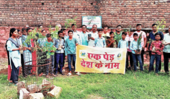 वृक्षारोपण में हिस्सा लेने वाले कार्यकर्ता और बच्चे