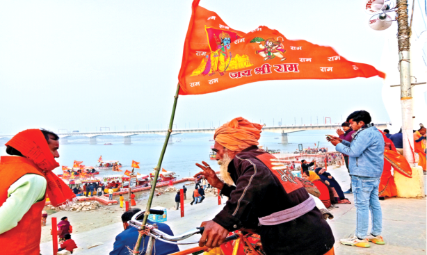 अयोध्या में सरयू तट पर राम ध्वज फहराता एक रामभक्त