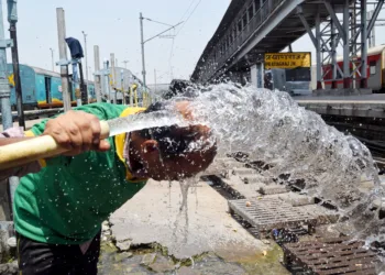 प्रयागराज में भीषण गर्मी से शांत होने के लिए वयक्ति ने पानी का लिया सहारा (Photo ANI)