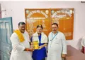 'लोक शिक्षा समिति' के सचिव रामलाल, सबसे दाएं, विद्यालय प्रबंधन समिति, किशनगंज के उपाध्यक्ष नन्द किशोर पोद्दार को प्रतीक चिह्न भेंट करते हुए। साथ में हैं प्राचार्य नागेन्द्र तिवारी