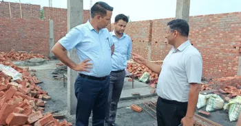 अवैध निर्माण की जांच करते अधिकारी