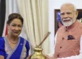 कमला प्रसाद बिसेसर को सरयू का पवित्र जल सौंपते प्रधानमंत्री नरेंद्र मोदी (फोटो साभार: द हिन्दू)