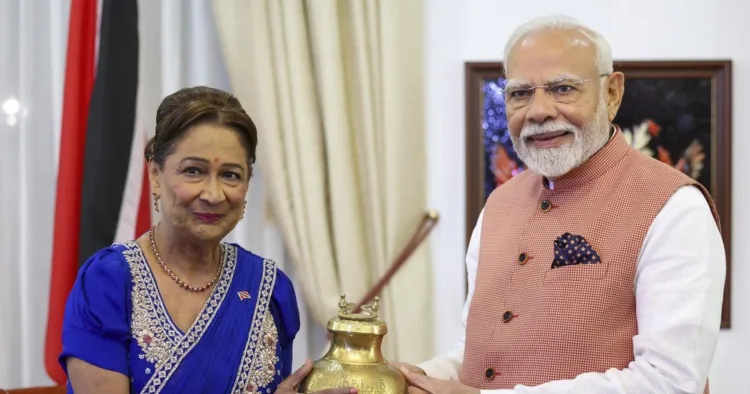 कमला प्रसाद बिसेसर को सरयू का पवित्र जल सौंपते प्रधानमंत्री नरेंद्र मोदी (फोटो साभार: द हिन्दू)
