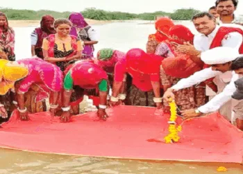 चुनरी ओढ़ाकर, फूल माला चढ़ाकर लूणी नदी की पूजा करते स्थानीय लोग