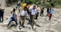 आपदा प्रभावित गांवों में राहत सामग्री लेकर जाते आरएसएस के स्वयंसेवक।