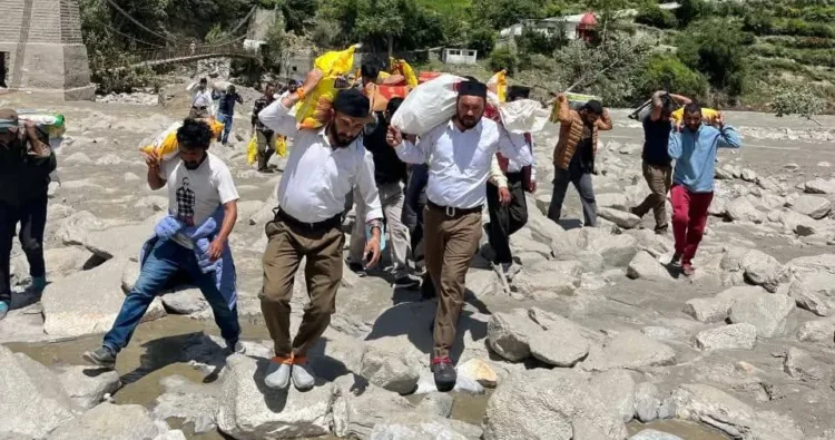 आपदा प्रभावित गांवों में राहत सामग्री लेकर जाते आरएसएस के स्वयंसेवक।