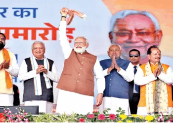 शपथग्रहण के बाद गमछा घुमाकर लोगों का अभिवादन करते प्रधानमंत्री नरेंद्र मोदी। साथ में हैं नीतीश कुमार, राज्यपाल आरिफ मोहम्मद खान और अन्य मंत्री