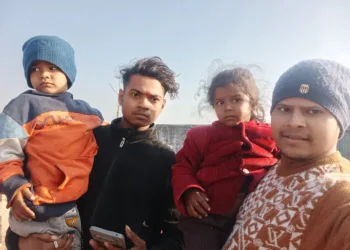 दोनों बच्चों को गोद में लिए हुए बजरंग दल के कार्यकर्ता