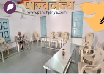 रसोई घर में बने हॉल में बैठकर खाना खाता एक बुजुर्ग