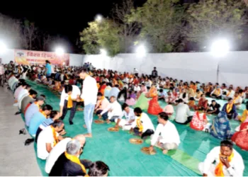 कार्यक्रम के बाद साथ बैठकर भोजन करते लोग