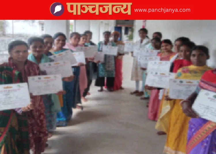 अपने प्रमाणपत्रों के साथ सिलाई का प्रशिक्षण प्राप्त करने वाली महिलाएं