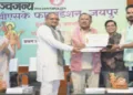 समारोह में एक पत्रकार को सम्मानित करते हुए श्री निम्बाराम और श्री वासुदेव देवनानी