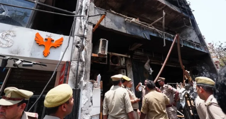 लखनऊ अग्निकांड की घटनास्थल पर जांच करते पुलिस अधिकारी