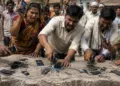 गांव वाले ईंट-पत्थरों से अपने फोन तोड़ते हुए (AI-generated image)